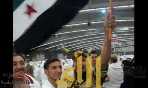 رجل أمن سعودي يرفع علم الثورة السورية